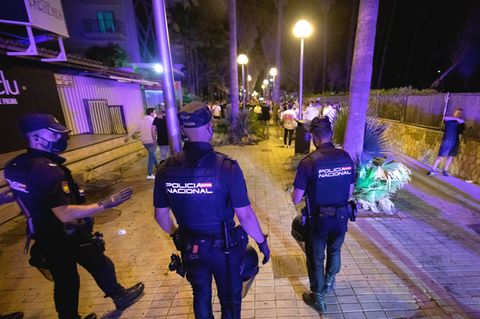 Nach der Sperrstunde der Bars feiern die Menschen am Strand von El Arenal. Die Polizei schickt das Partyvolk immer wieder weg.