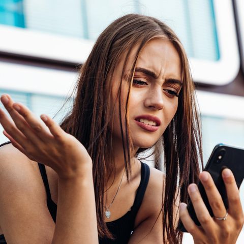 Frau schaut verständnislos aufs Handy