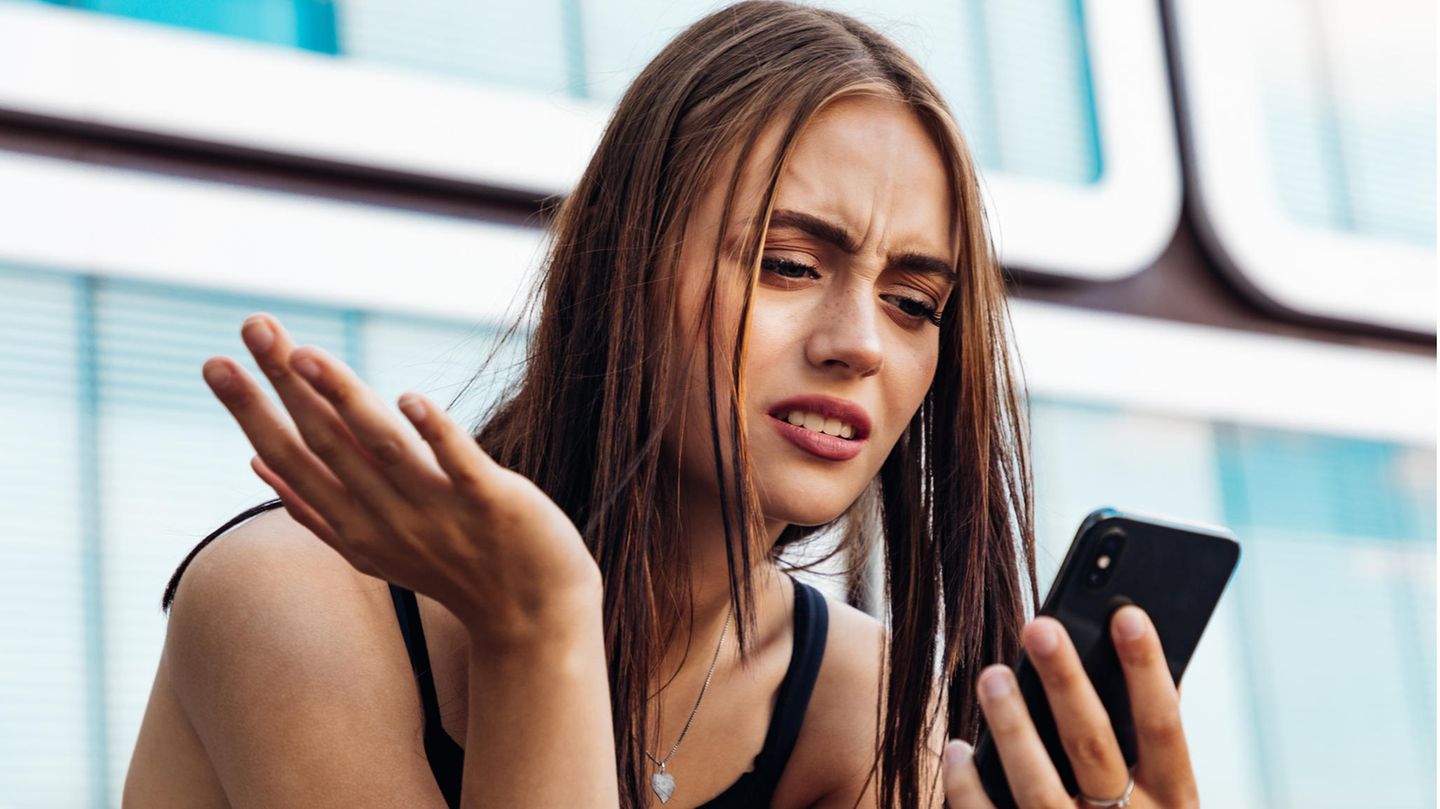 Frau schaut verständnislos aufs Handy