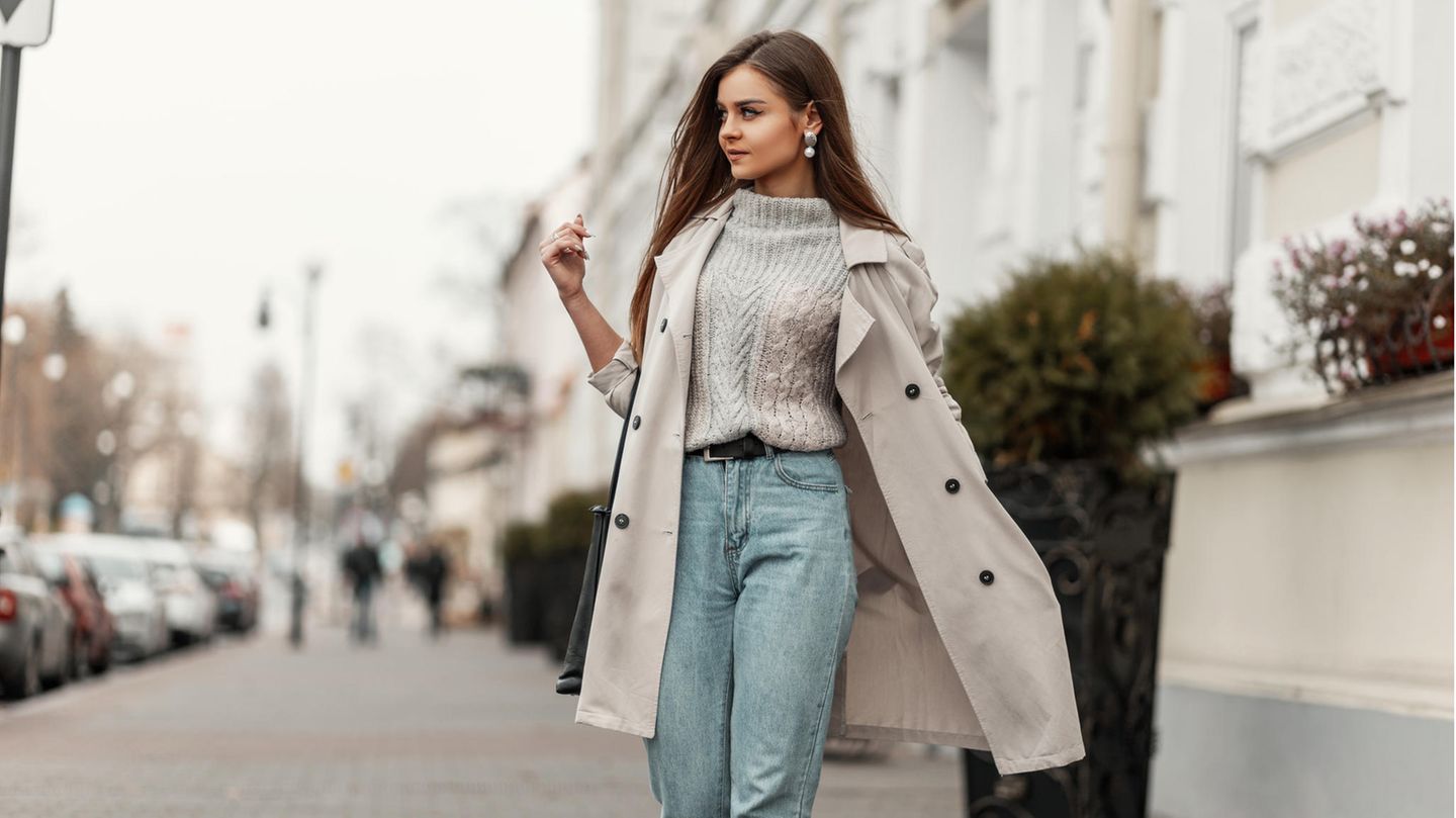 Frau auf der Straße in Mom Jeans und Trenchcoat