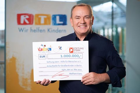 RTL-Moderator Wolfram Kons mit einem Scheck über eine Million Euro für Straßenkinder in Berlin an die Stiftung stern