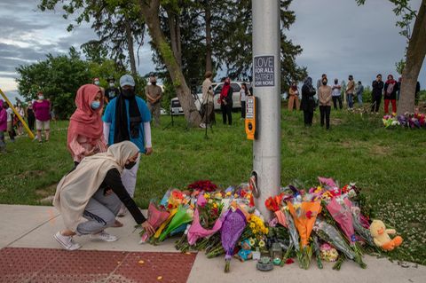 Frauen mit Hijab trauern um die Opfer eines mutmaßlich antimuslimischen Angriffs und legen Blumen an einer Ampel nieder