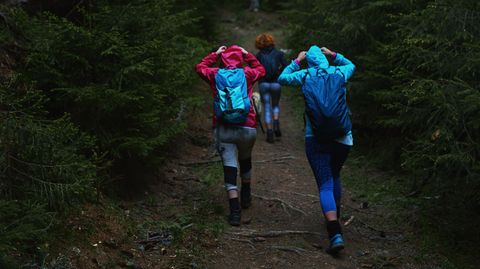 Wasserdichter Rucksack: Drei Wanderer mit Rucksäcken bei Regenwetter