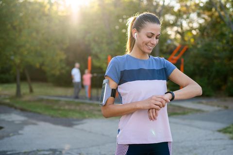 Eine Läuferin schaut auf ihre Fitness-Uhr