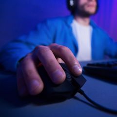 MMO-Maus: Ein Mann spielt am Computer. Mit seiner rechten Hand steuert er die Maus.