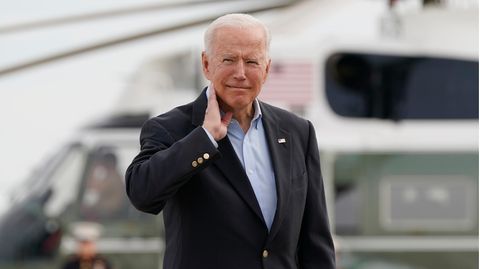 Joe Biden, Präsident der USA, stellt nach, wie er sich zuvor eine Heuschrecke vom Hals jagen musste