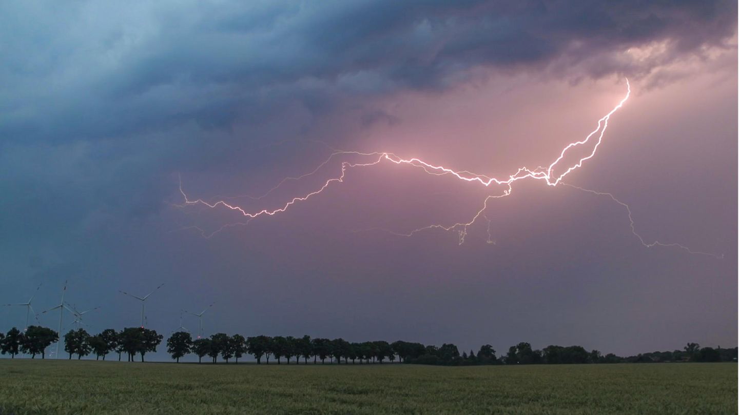 Ein Blitz erhellt den Abendhimmel über der Landschaft im Landkreis Oder-Spree. Wie ein Gewitter entsteht, erfahren Sie unten.