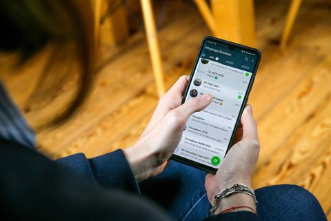 Eine Perosn blickt auf ihre geöffnete Chat-Liste bei WhatsApp