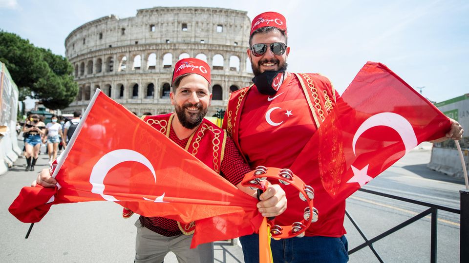 Türkische Fans in Rom machen auf dem Weg ins Stadion Halt vor der prächtigen Kulisse des Colosseums