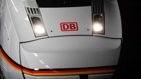 Die weiße Lok eines ICE 4 steht mit rotem "DB"-Logo zwischen den angeschalteten Scheinwerfern in einem Bahnhof
