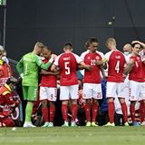 Der dänische Nationalspieler Christian Eriksen wird auf dem Feld behandelt