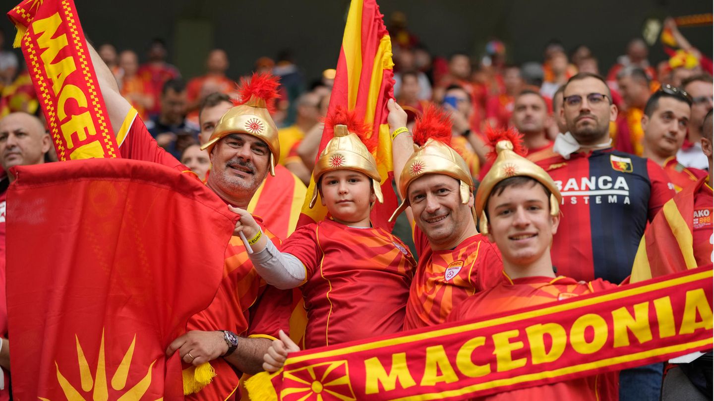 Eine wahre Fan-Familie: Mit Kampfhelmen aus Plastik und in den Farben von Nordmazedonien ausgestattet fiebern in Bukarest beim Spiel ihrer Mannschaft gegen Österreich mit