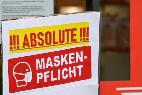 "Absolute Maskenpflicht" steht auf einem Schild am Eingang eines Geschäfts