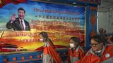 Die Journalistengruppe wird unter anderem durch eine tibetische Schule geführt. Zu den Schülern winkt zweisprachig Chinas Präsident Xi Jinping von der Wand.