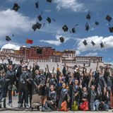 Heile Welt mit hochfliegenden Hüten der Studierenden in Lhasa mit dem Potala-Palast im Hintergrund.