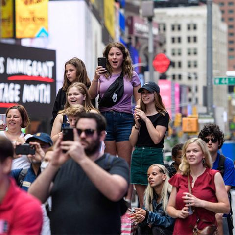 Passanten in New York City (USA) beobachten auf dem Times Square ein Pop-up-Event