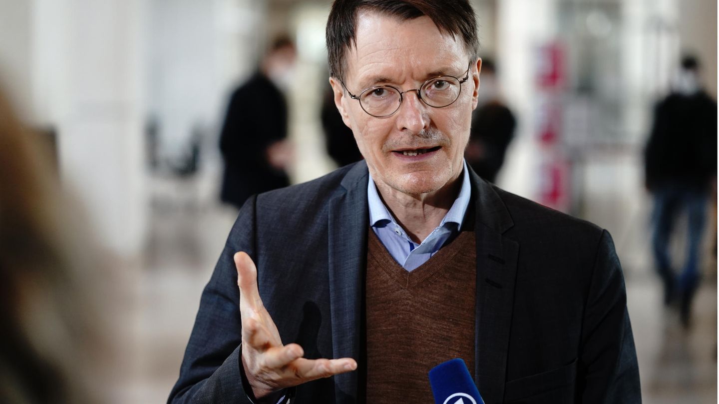 Karl Lauterbach spricht in ein Mikrofon und gestikuliert