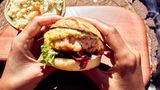 Shrimp-Burger mit Ananas Cole Slaw  Zutaten:   Für den Coleslaw: ½ Kopf Weißkohl, 1 kleine Ananas, 2 Becher Crème fraîche (à ca. 150 g), 1 TL Currypulver, frisch gemahlener schwarzer Pfeffer, 1 unbehandelte Limette  Für die Burgersauce: 1 Bund frischer Dill, 1 EL Dijonsenf, 4 EL Mayonnaise  Für die Shrimp-Pattys: 500 g rohe, küchenfertige Riesengarnelen in der Schale (Black Tiger Prawns), ½ Limette, Salz, frisch gemahlener schwarzer Pfeffer, 2 EL Maisstärke, Butter zum Anbraten  Ausserdem: 2 Briochebrötchen bunter Blattsalat  Zubereitung: Für den Coleslaw den Strunk des Weißkohls entfernen, den Kohl in feine Streifen schneiden, waschen und trockenschütteln. Die Ananas schälen, das harte Strunkstück entfernen und das Fruchtfleisch in kleine Würfel schneiden. Den Weißkohl und die Ananas mit der Crème fraîche vermengen. Mit dem Currypulver und Pfeffer würzen. Die Limette heiß abwaschen und die Schale fein abreiben. Diese für die Burgersauce aufheben. Die Limette pressen und den Saft unter den Coleslaw rühren. Den Coleslaw abgedeckt für mindestens 2 Stunden an einem kühlen Ort durchziehen lassen. Für die Burgersauce den Dill waschen, trockenschütteln und fein hacken. Den Dill mit dem Senf, der Mayonnaise und der abgeriebenen Limettenschale glatt verrühren. Für die Shrimp-Pattys die Garnelen aus der Schale lösen und in eine Schüssel geben. Anschließend mit dem Saft der ½ Limette sowie je 1 Prise Salz und Pfeffer würzen. Die gewürzten Garnelen mit einem Stabmixer grob pürieren. Die Maisstärke dazugeben und alles zu einer homogenen Masse verkneten. Aus der Masse 2 Pattys formen und in etwas Butter in einer Pfanne von beiden Seiten kross anbraten. In der Zwischenzeit die Briochebrötchen halbieren, auf den Innenseiten anrösten und auf Teller verteilen. Den Blattsalat waschen und trockenschütteln. Die unteren Brötchenhälften mit Salat belegen, Burgersauce daraufgeben und die Shrimp-Pattys obenauf legen. Die oberen Brötchenhälften aufsetzen. Die Burger mit dem Coleslaw und je einem Glas Sekt servieren.