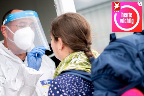 Ein Mitarbeiter eines Testcenters in Niedersachsen nimmt einen Abstrich von einer jungen Frau