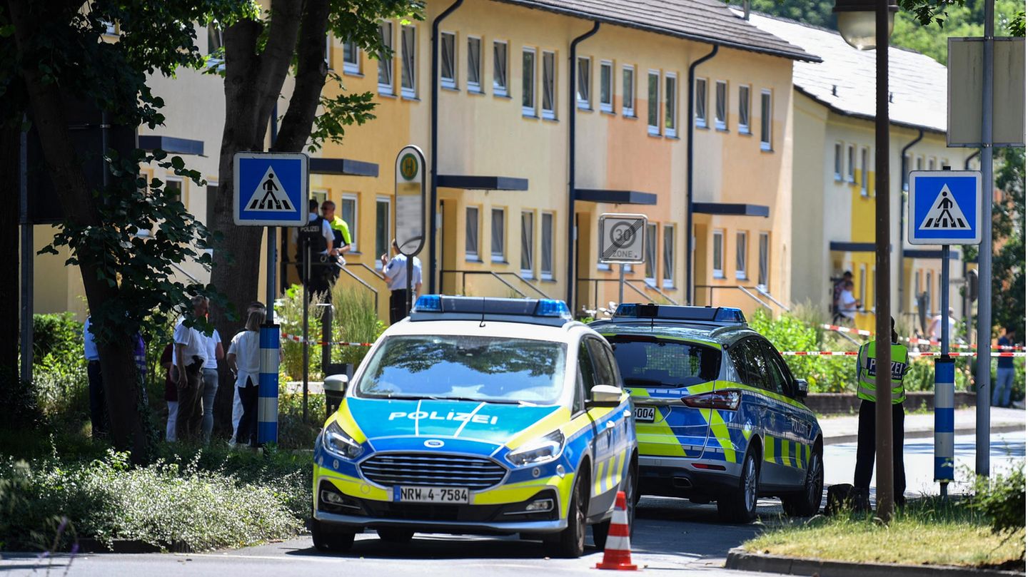 Polizeibeamte stehen vor einem Haus