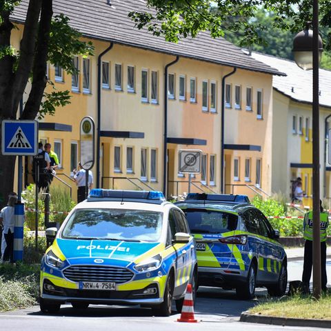 Polizeibeamte stehen vor einem Haus
