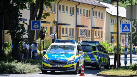 Polizeibeamte stehen vor einem Haus