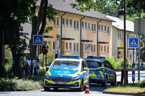Polizeibeamte stehen vor einem Haus