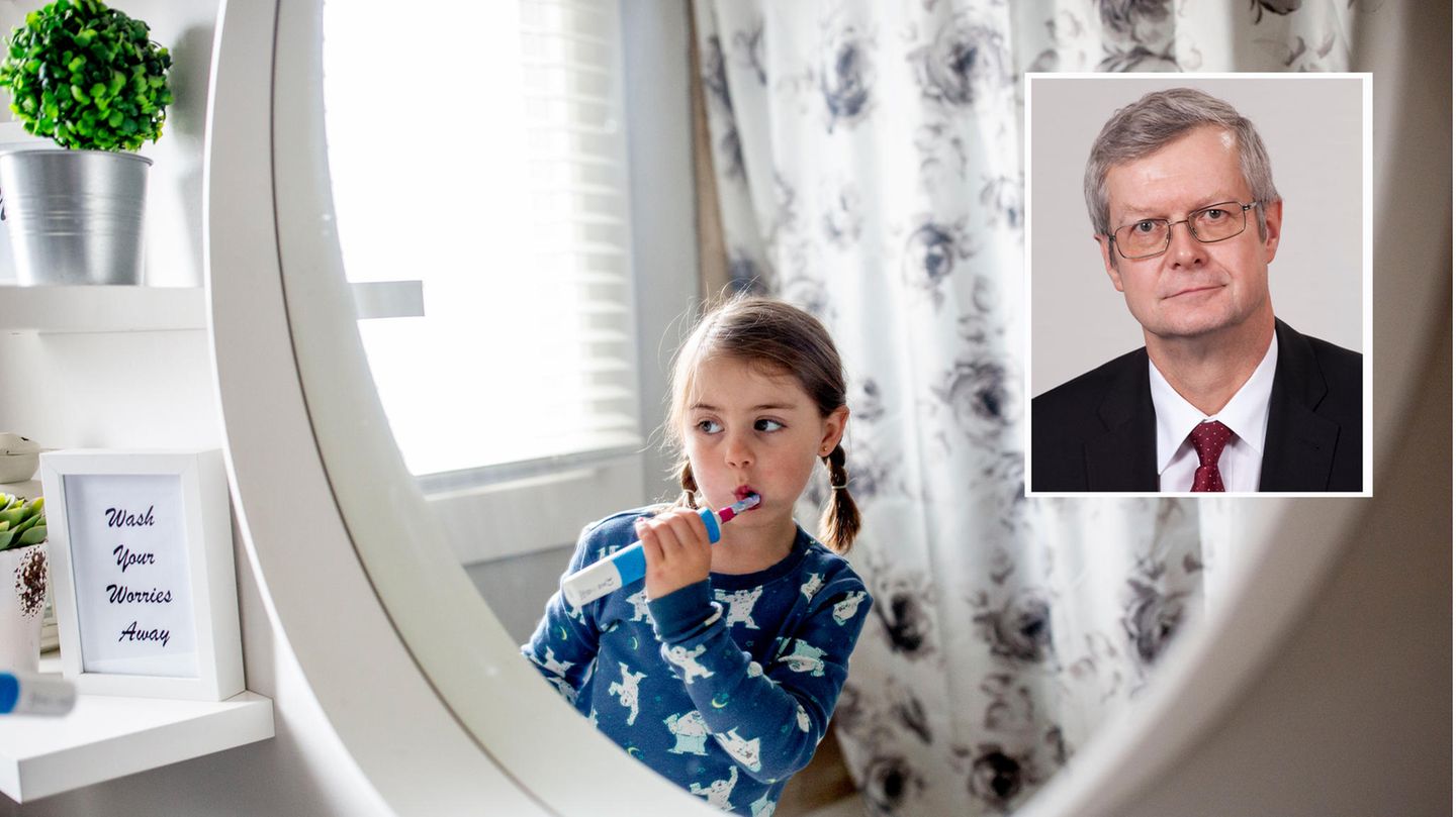 Elektrische Zahnbürsten: Kleines Mädchen putzt ihre Zähne vor einem Spiegel