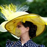 Der Mundschutz passt sich farblich an die opulente Kopfbedeckung an