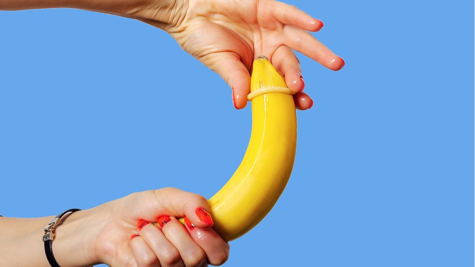 Ein Kondom wird über eine Banane gezogen