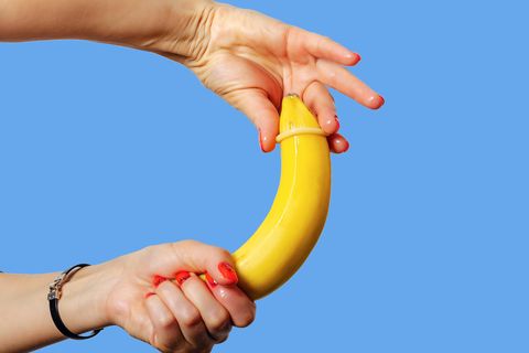 Ein Kondom wird über eine Banane gezogen