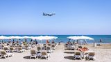 Corona-Regeln auf Zypern. Auf dem Foto zu sehen ist ein Strand und ein Flugzeug im Landeanflug