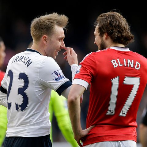 Von hinten sind zwei Fußball-Profis zu sehen, die sich unterhalten. "Eriksen" steht auf dem weißen Trikot, "Blind" auf dem roten