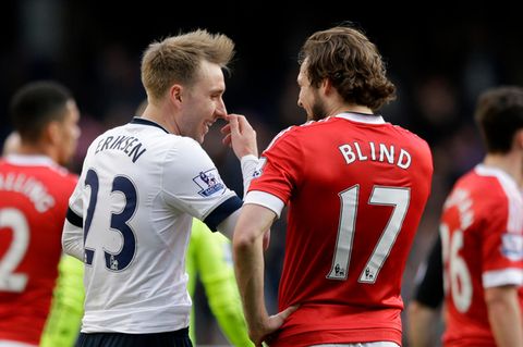 Von hinten sind zwei Fußball-Profis zu sehen, die sich unterhalten. "Eriksen" steht auf dem weißen Trikot, "Blind" auf dem roten