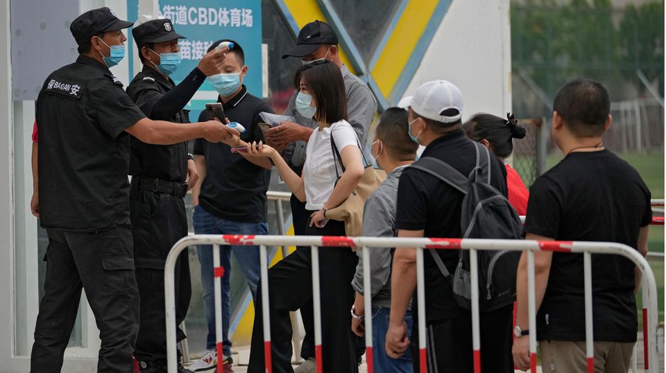 Sicherheitskräfte helfen Menschen beim Scannen ihres Gesundheitscodes