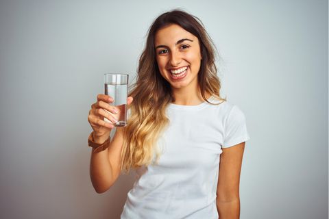Wasser trinken Hitze: Eine Frau trinkt ein Glas mit Wasser