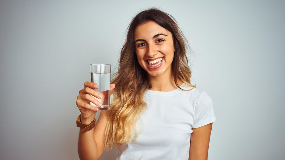 Wasser trinken Hitze: Eine Frau trinkt ein Glas mit Wasser