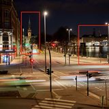 Mit scharfem Auge ist auf dem Gebäude am linken Bildrand das Firmenlogo von Hamburg Wasser zu erahnen. Kenner der Hansestadt dürften zudem das Rathaus oder die beleuchteten Einkaufshäuser am Jungfernstieg samt Binnenalster erkannt haben. Entsprechend ist das Bild in etwa hier entstanden.