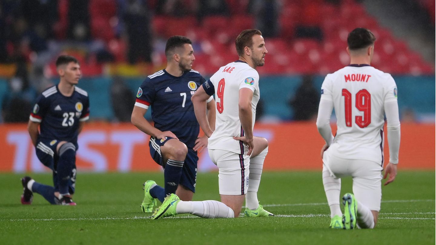 Schottische und englische Spieler knien auf dem Rasen von Wembley