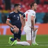 Schottische und englische Spieler knien auf dem Rasen von Wembley