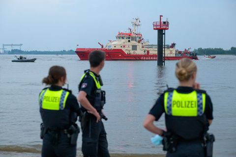Polizisten beobachten Suchaktion auf der Elbe