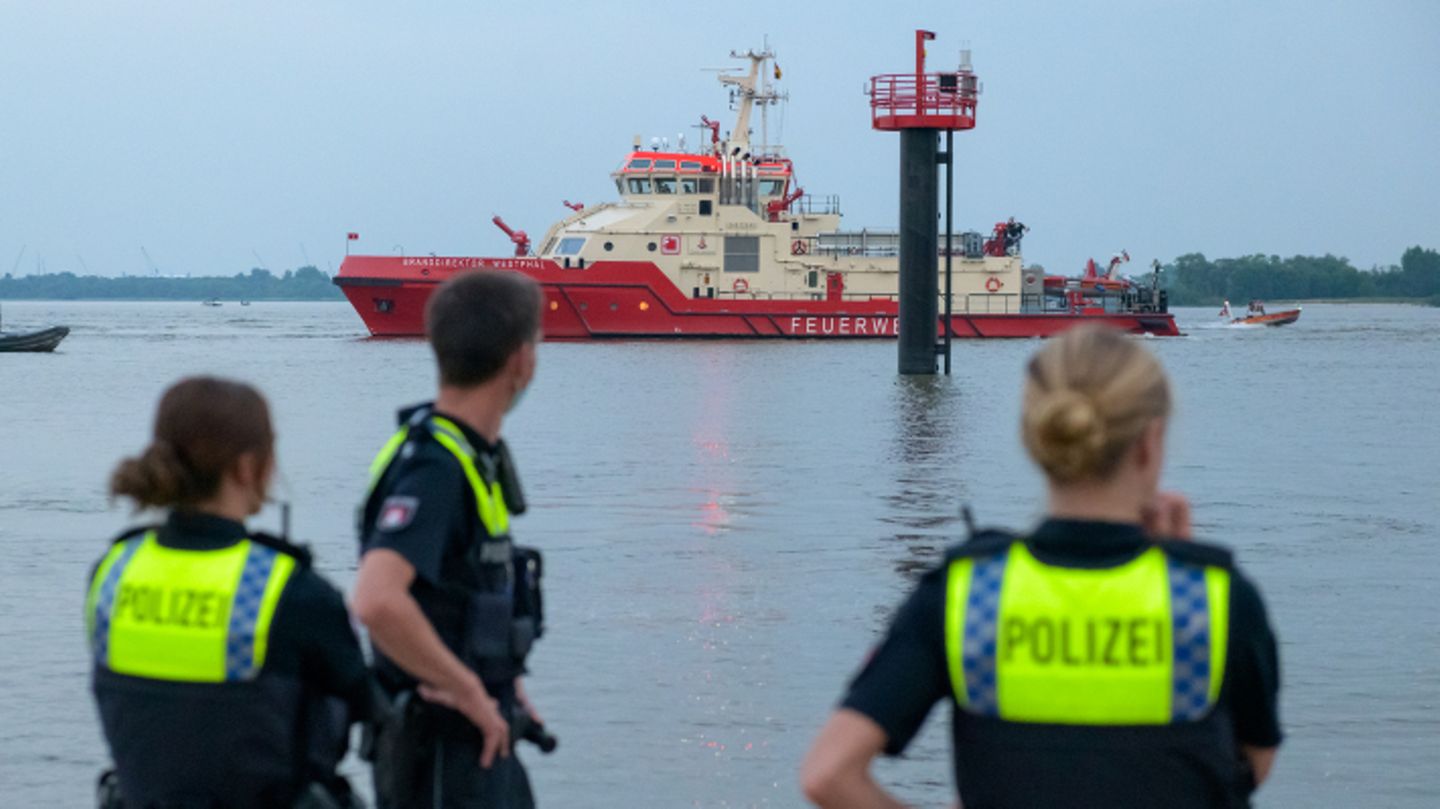 Polizisten beobachten Suchaktion auf der Elbe