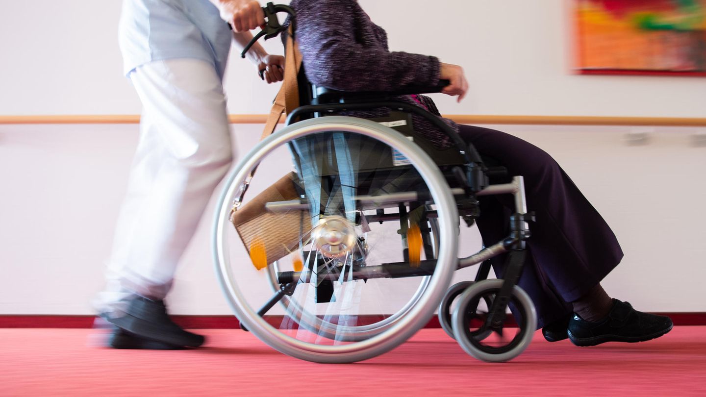 Elderly care: A caregiver pushes a nursing home resident in a wheelchair