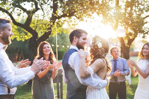 Ein Hochzeitspaar tanzt umgeben von Gästen