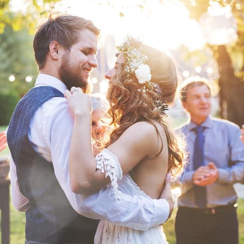 Ein Hochzeitspaar tanzt umgeben von Gästen
