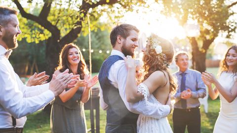 Ein Hochzeitspaar tanzt umgeben von Gästen