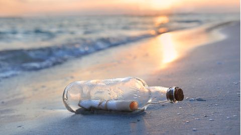 Flaschenpost liegt am Strand