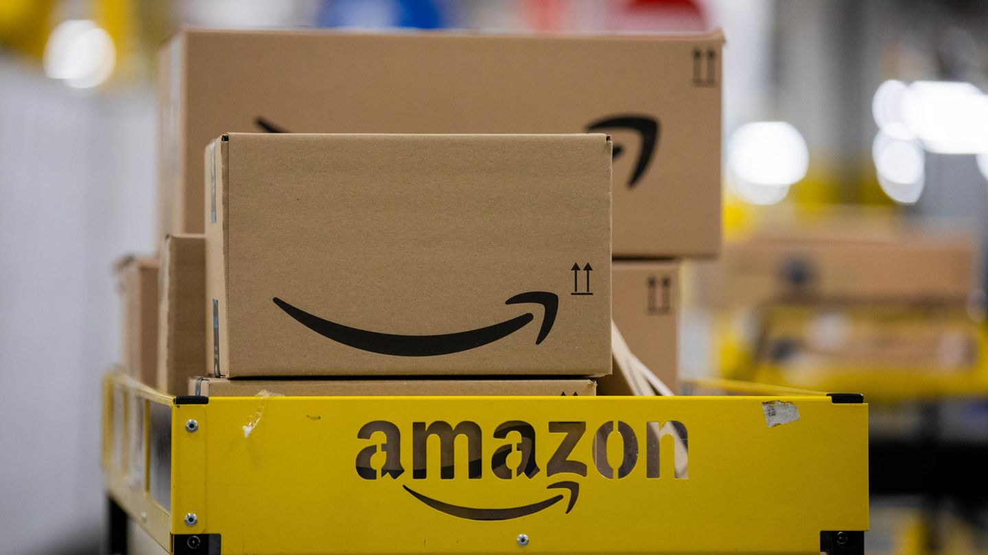Pakete liegen in einem Logistikzentrum des Versandhändlers Amazon auf einem Wagen