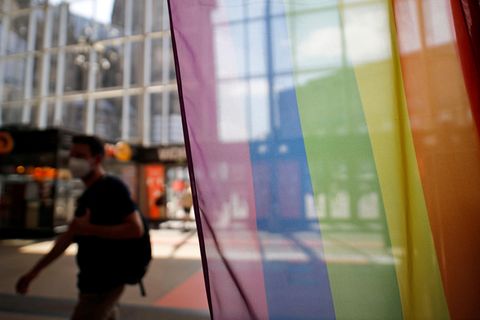 Vor dem Infoschalter der Deutschen Bahn im Kölner Hauptbahnhof stehen Regenbogenflaggen