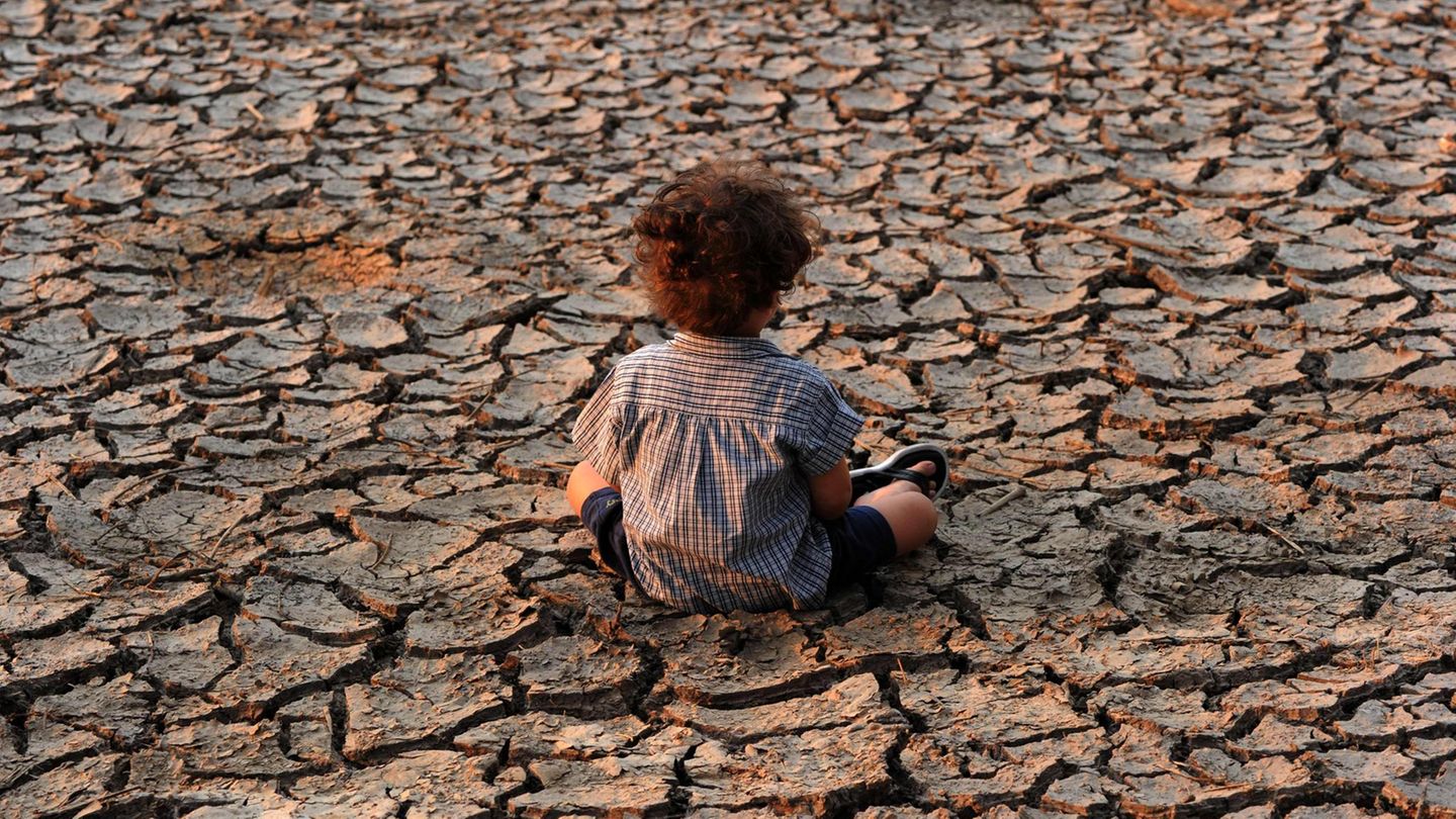 Symbolbild für Klimawandel: Ein Kind sitzt auf ausgedörrter Erde in der Nähe der Stadt Tegucigalpa, der Hauptstadt von Honduras